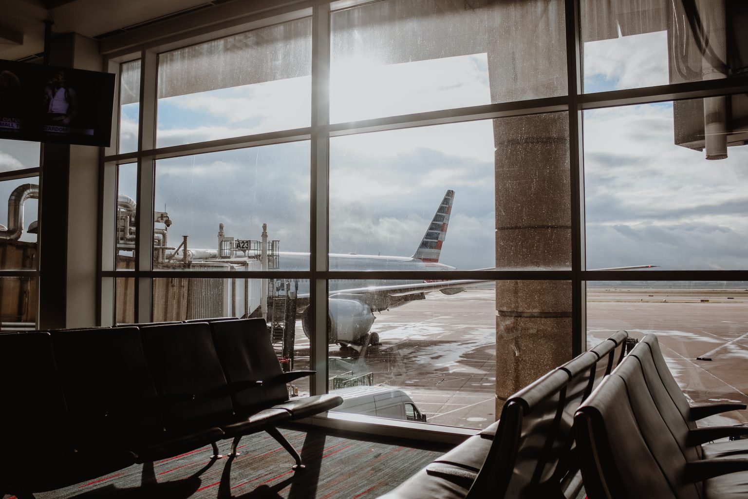 View of airplane from airport gate to represent business travel policy